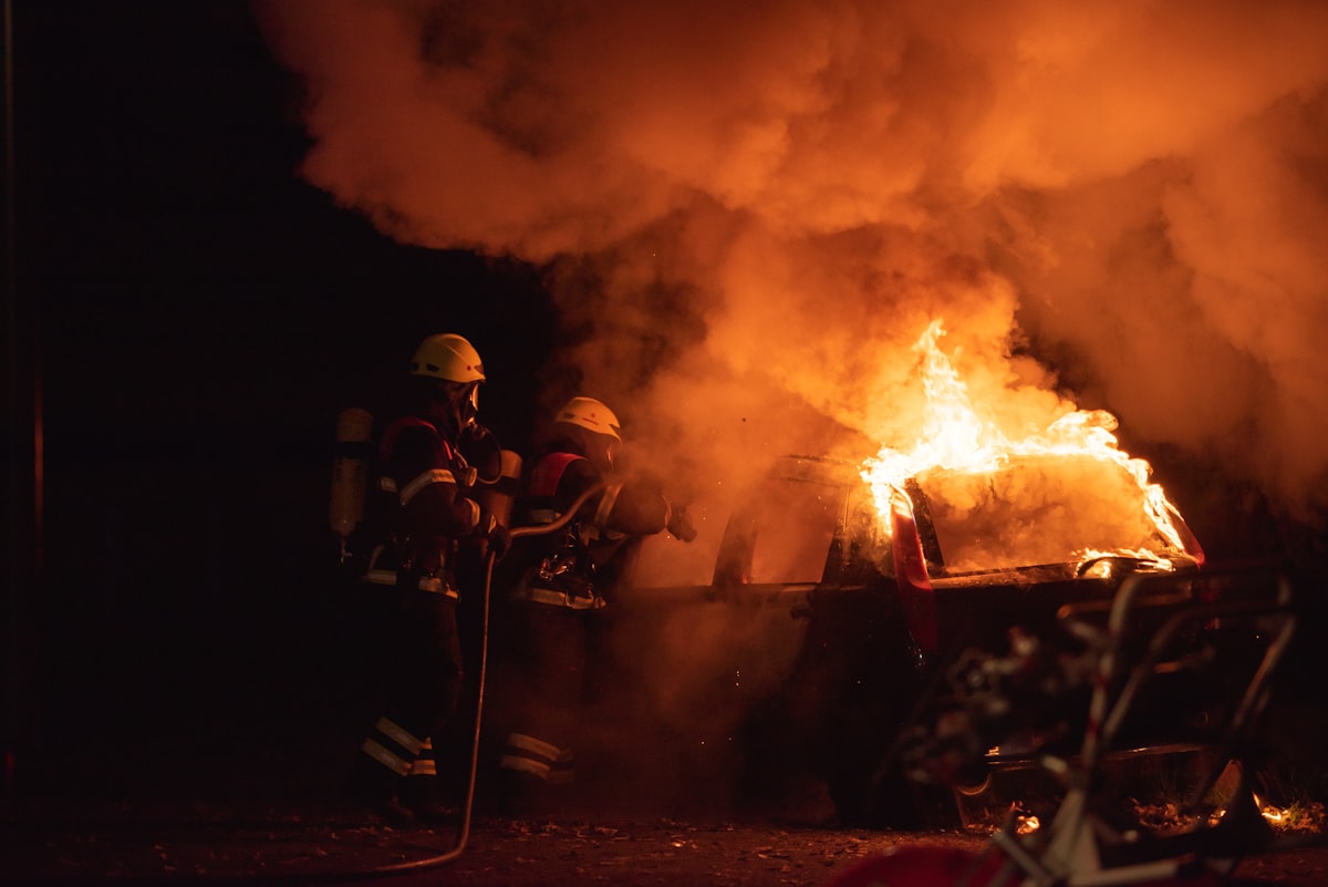 Firefighters working a vehicle fire at night